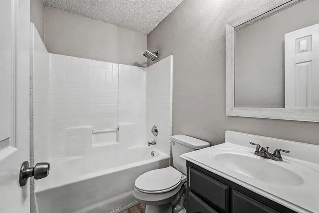 a bathroom with a granite countertop toilet sink and a mirror