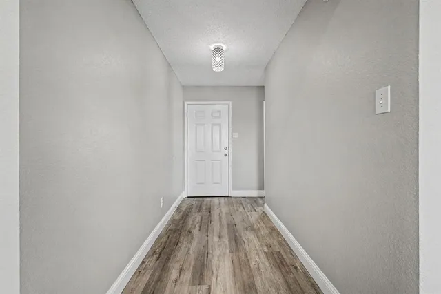 a view of a hallway with wooden floor
