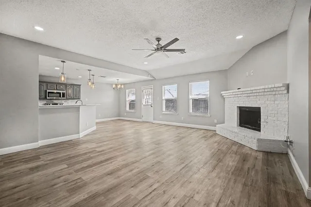a view of empty room with wooden floor and fireplace