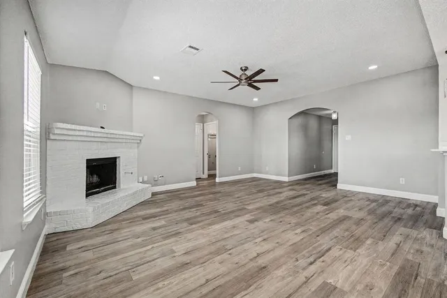 a view of an empty room with a fireplace and a window