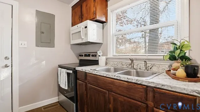 a kitchen with stainless steel appliances granite countertop a sink a stove and a refrigerator