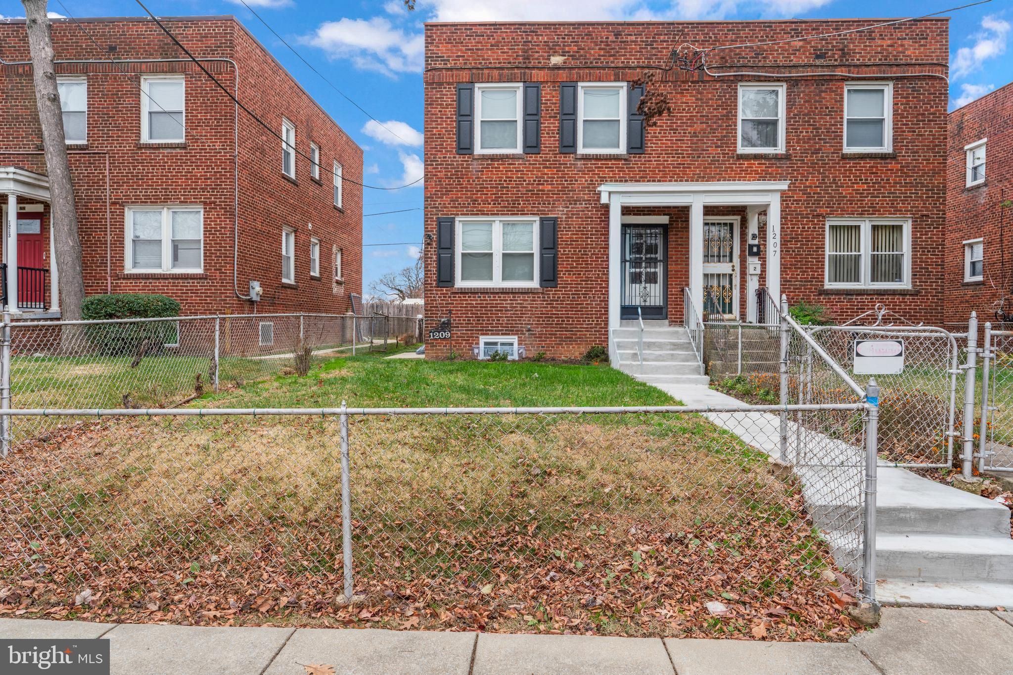 1209 Savannah Street Southeast Washington, DC 20032 - Photo 2 of 27 front view of a brick house with a yard