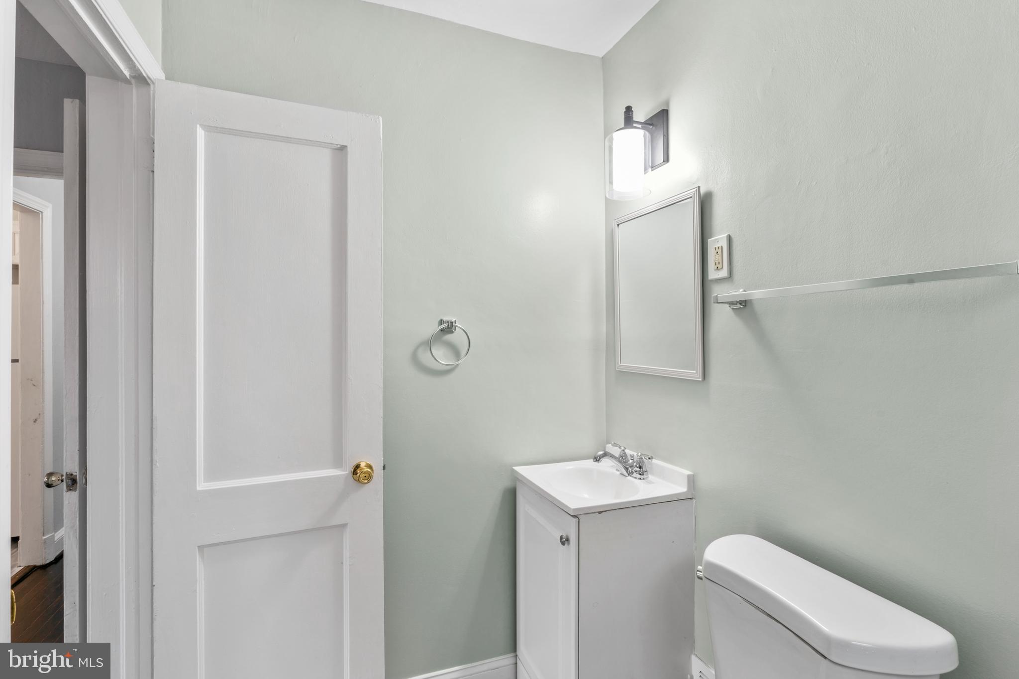 1209 Savannah Street Southeast Washington, DC 20032 - Photo 21 of 27 a bathroom with a toilet a sink and mirror