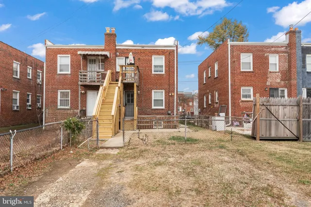 a view of a brick house with many windows next to a road