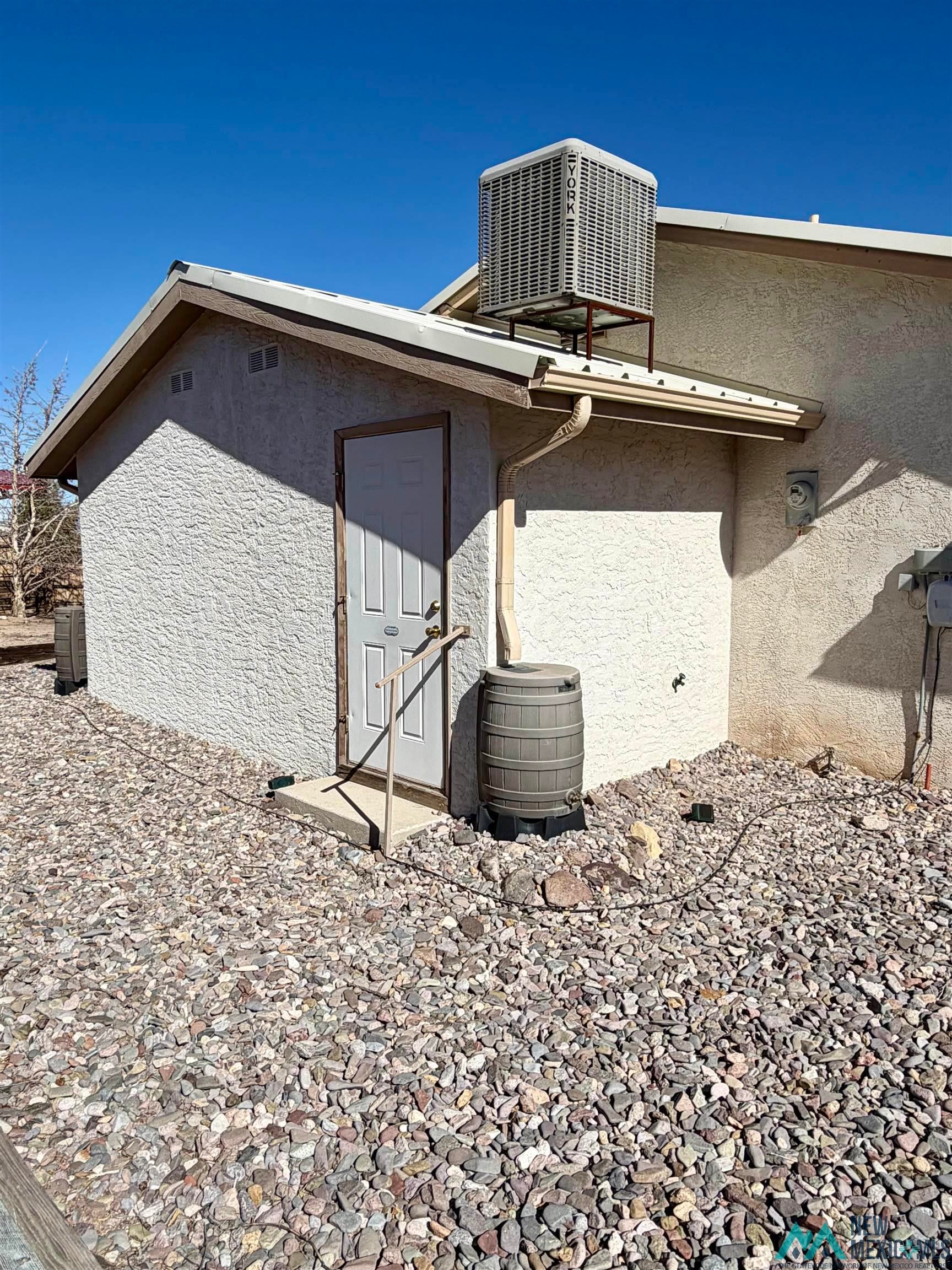 109 Mimbres Road Elephant Butte, NM 87935 - Photo 27 of 27 View of property exterior featuring a central AC unit and stucco siding