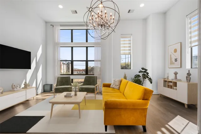 a living room with furniture a flat screen tv and a chandelier