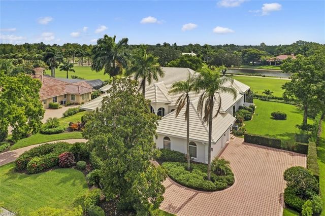 a view of a house with a yard and potted plants