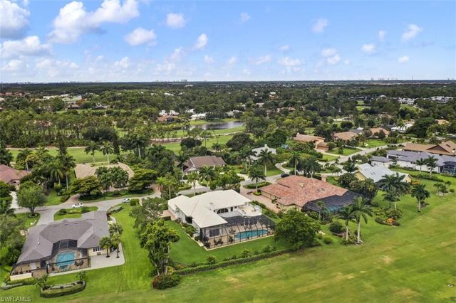 an aerial view of residential houses with outdoor space and trees