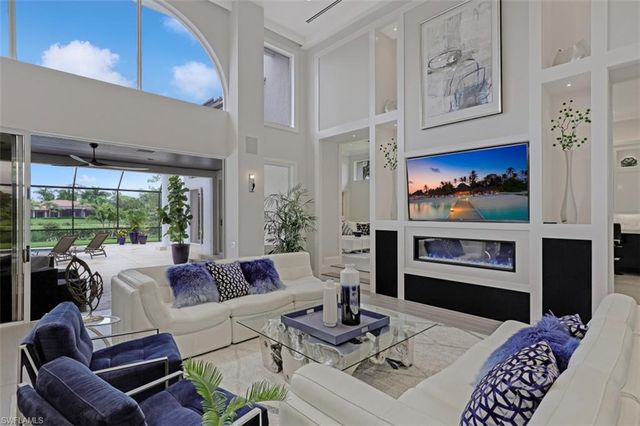a living room with furniture fireplace and large window