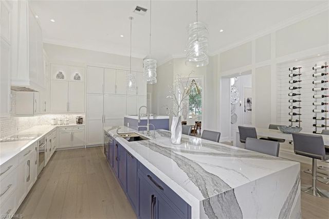 a large kitchen with kitchen island a sink a center island a counter space and a view of living room