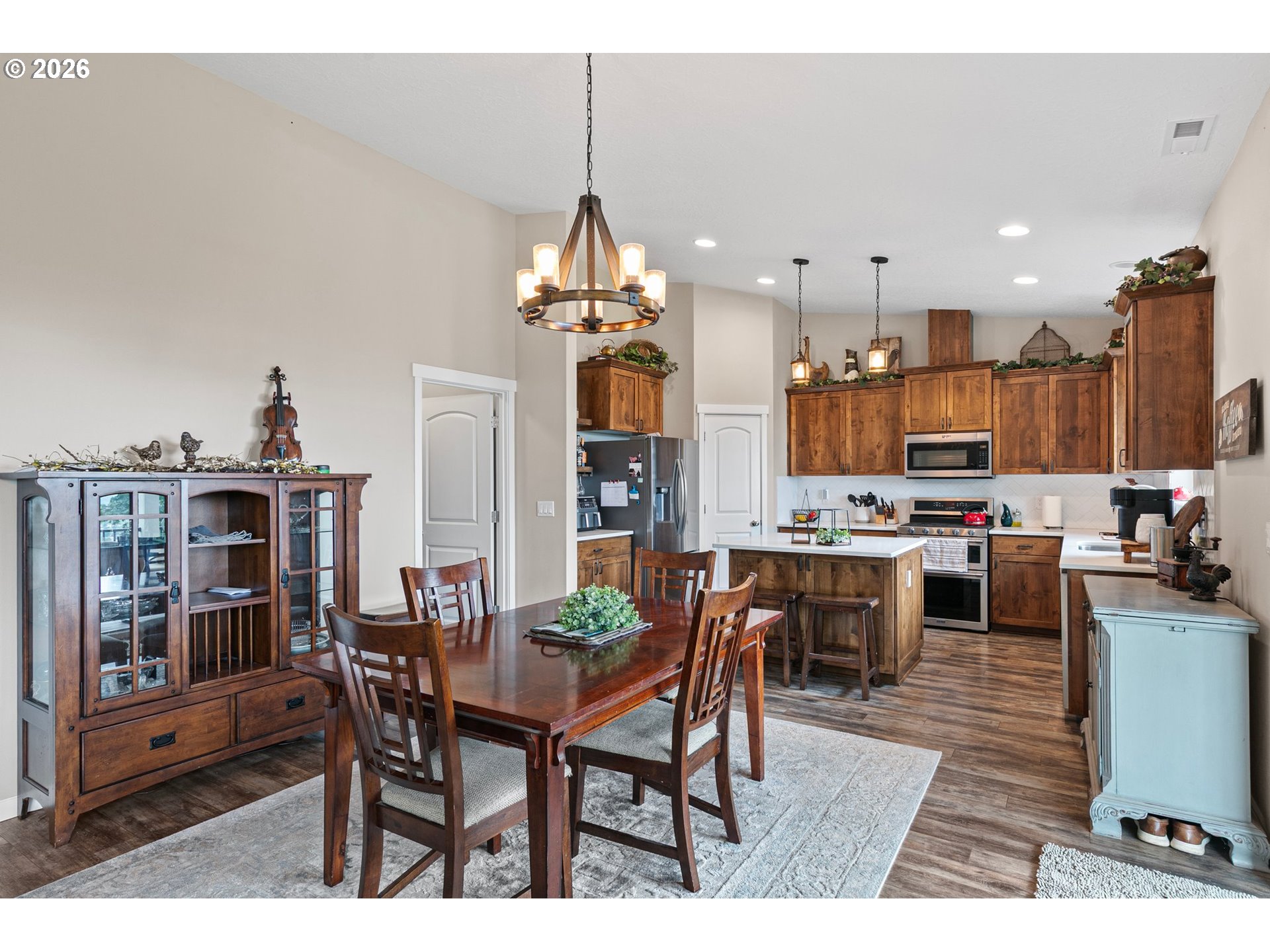 962 South 66th Place Springfield, OR 97478 - Photo 8 of 44 a kitchen with stainless steel appliances kitchen island granite countertop a dining table chairs and a oven