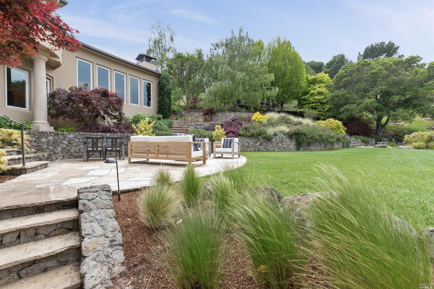 a view of a house with backyard and sitting area