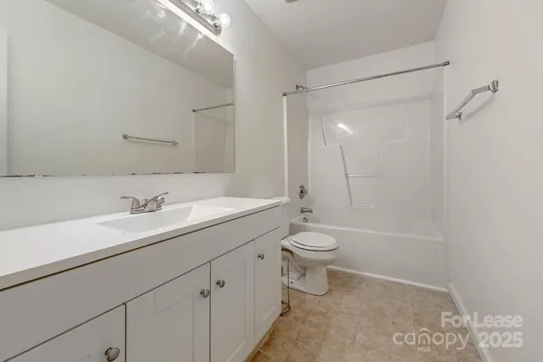 a bathroom with a sink a toilet and a large mirror