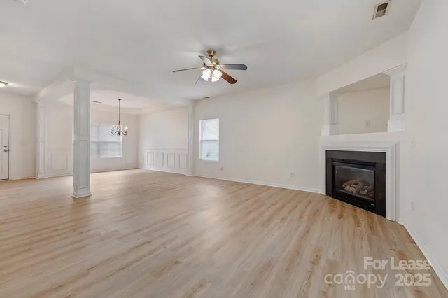 a view of empty room with wooden floor and fireplace