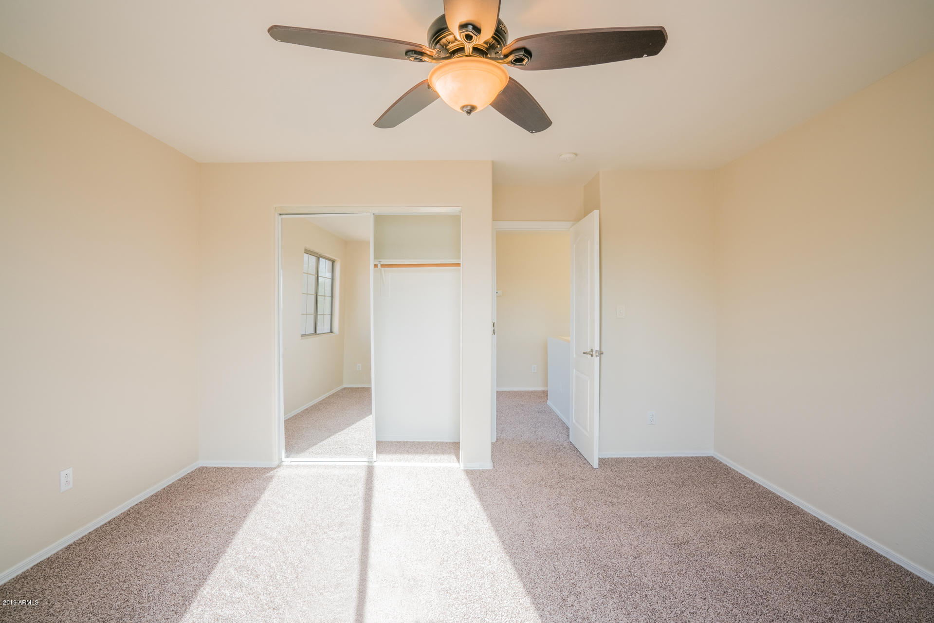 15441 West Shangri La Road Surprise, AZ 85379 - Photo 19 of 24 an empty room with closet and a chandelier fan