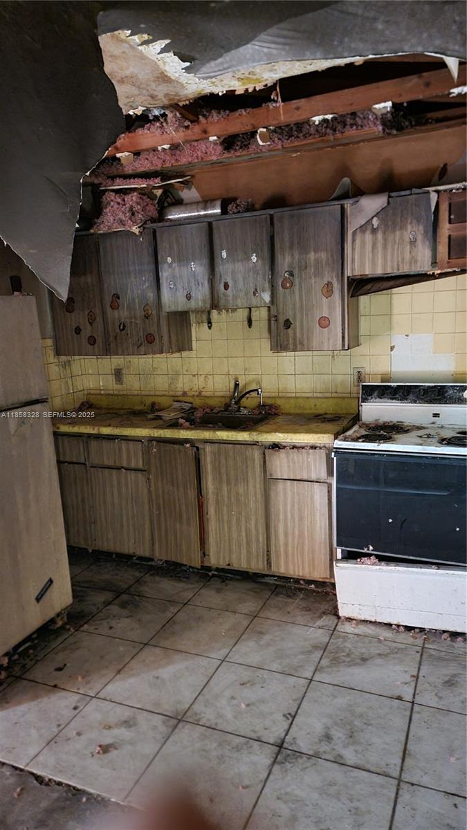 917 West 2nd Street Riviera Beach, FL 33404 - Photo 8 of 8 a kitchen with a stove top oven and cabinets