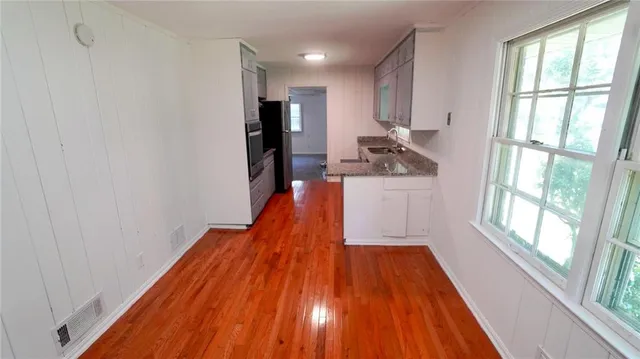 a kitchen with wooden floor and a window
