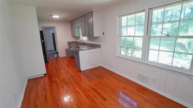 a kitchen with stainless steel appliances wooden floors and large window