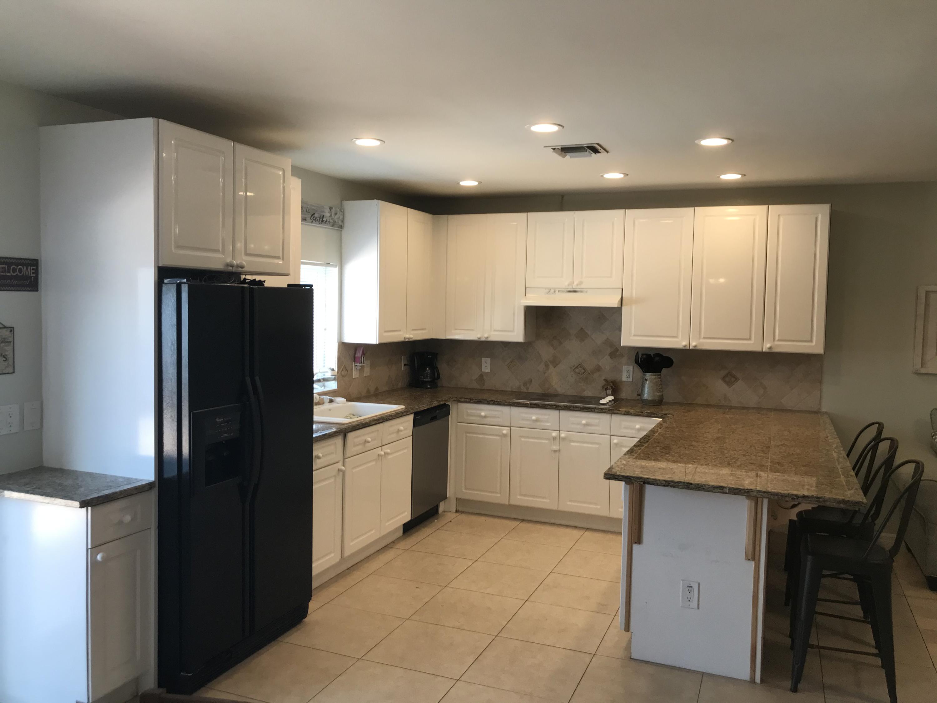 680 Southwest 17th Court Boca Raton, FL 33486 - Photo 18 of 27 a kitchen with a refrigerator and a stove top oven