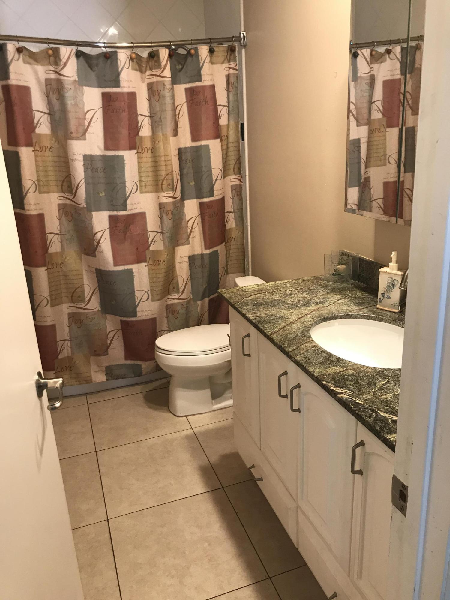 680 Southwest 17th Court Boca Raton, FL 33486 - Photo 26 of 27 a bathroom with a granite countertop toilet sink and mirror