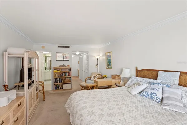 a bedroom with a large bed and a flat tv screen on dresser
