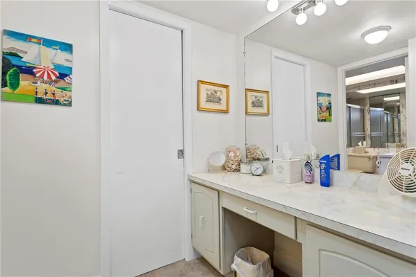 a bathroom with a sink a mirror and painting on the wall
