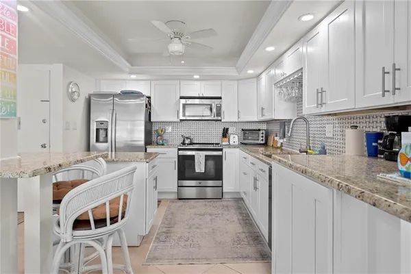 a kitchen with stainless steel appliances granite countertop a sink stove and refrigerator