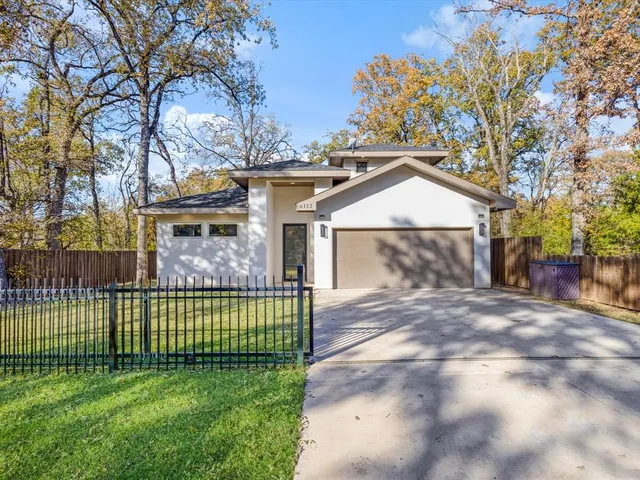 a front view of a house with a garden and plants
