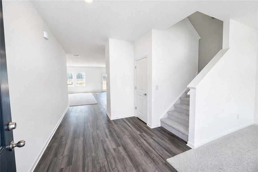 44 Rowlett Place Winder, GA 30680 - Photo 2 of 47 a view of a hallway with wooden floor and staircase