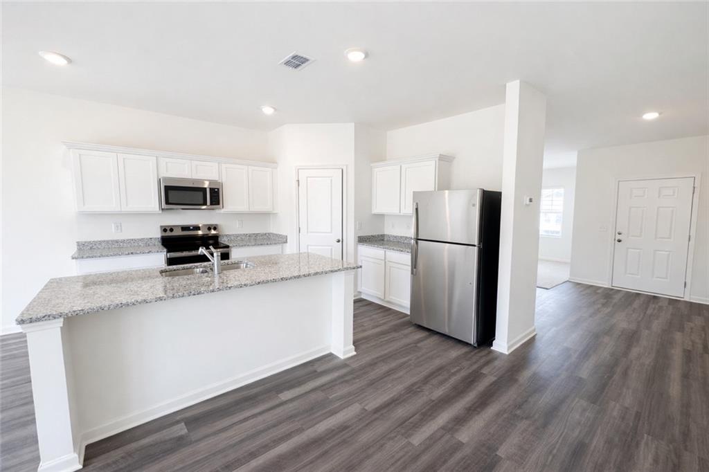 44 Rowlett Place Winder, GA 30680 - Photo 5 of 47 a kitchen with stainless steel appliances granite countertop a refrigerator stove a sink and a microwave