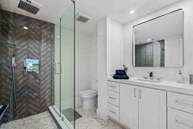 a bathroom with a double vanity sink a toilet and a mirror