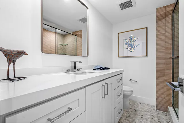 a bathroom with a sink a toilet and a mirror