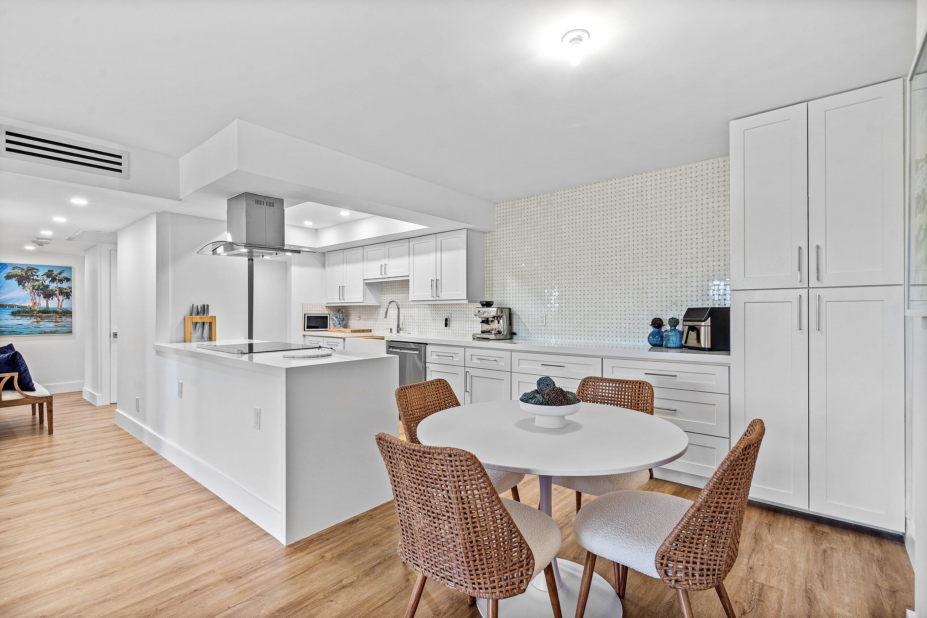 1111 South Ocean Boulevard, Unit 4210 Boca Raton, FL 33432 - Photo 4 of 28 a kitchen with a dining table chairs and wooden floor