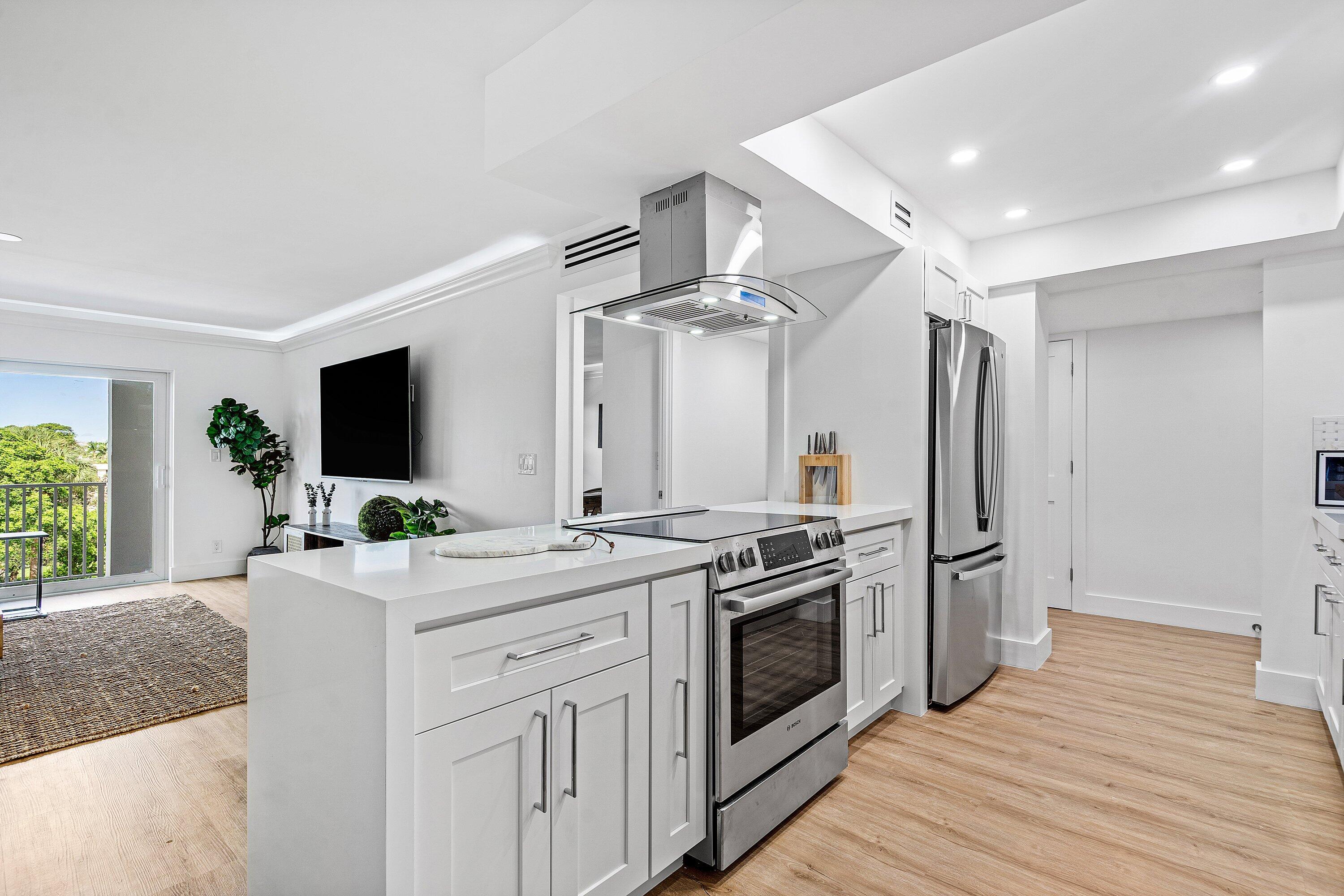 1111 South Ocean Boulevard, Unit 4210 Boca Raton, FL 33432 - Photo 8 of 28 a kitchen with stainless steel appliances a sink stove and cabinets