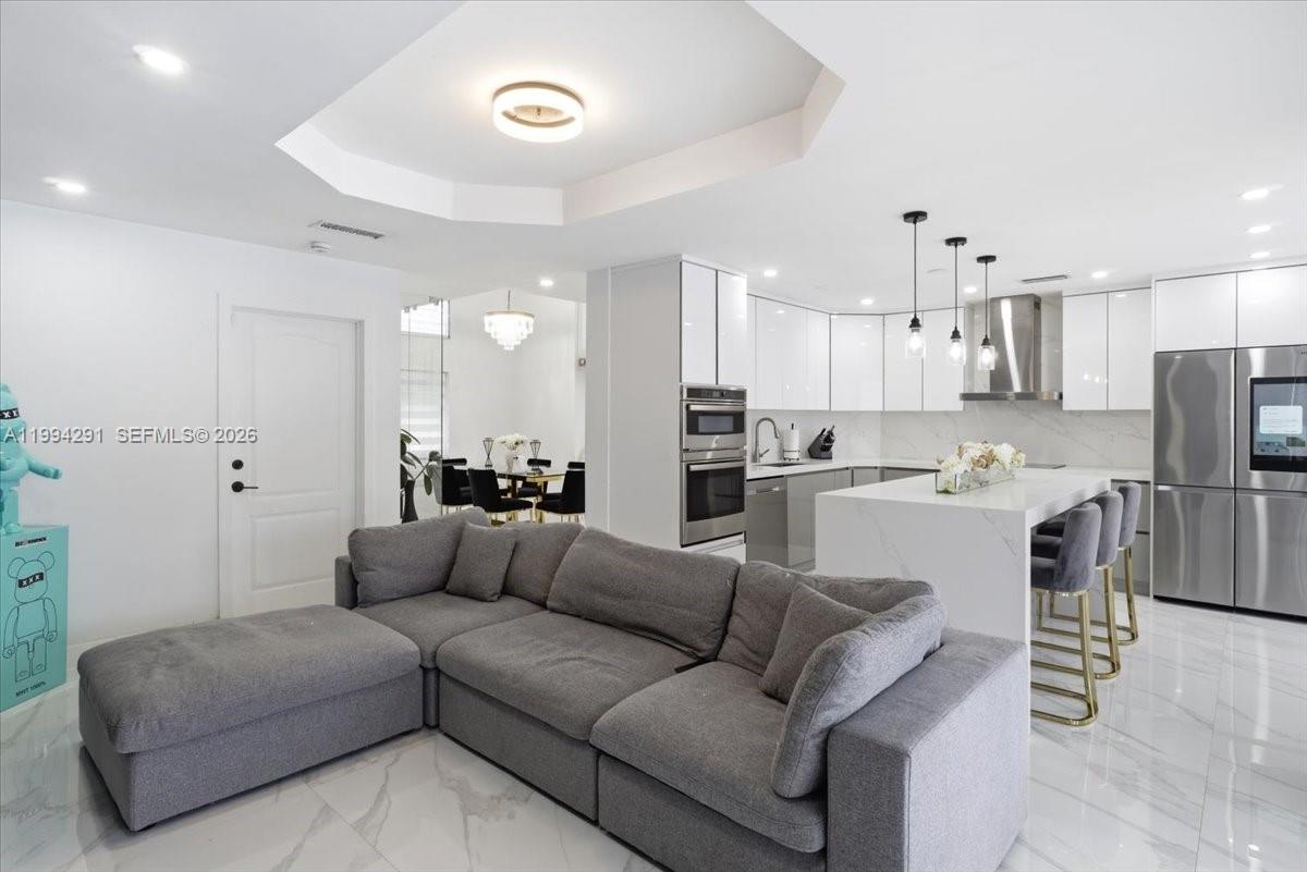 15763 Southwest 43rd Street Miami, FL 33185 - Photo 12 of 46 a view of kitchen with kitchen island stainless steel appliances refrigerator stove a sink a dining table and chairs