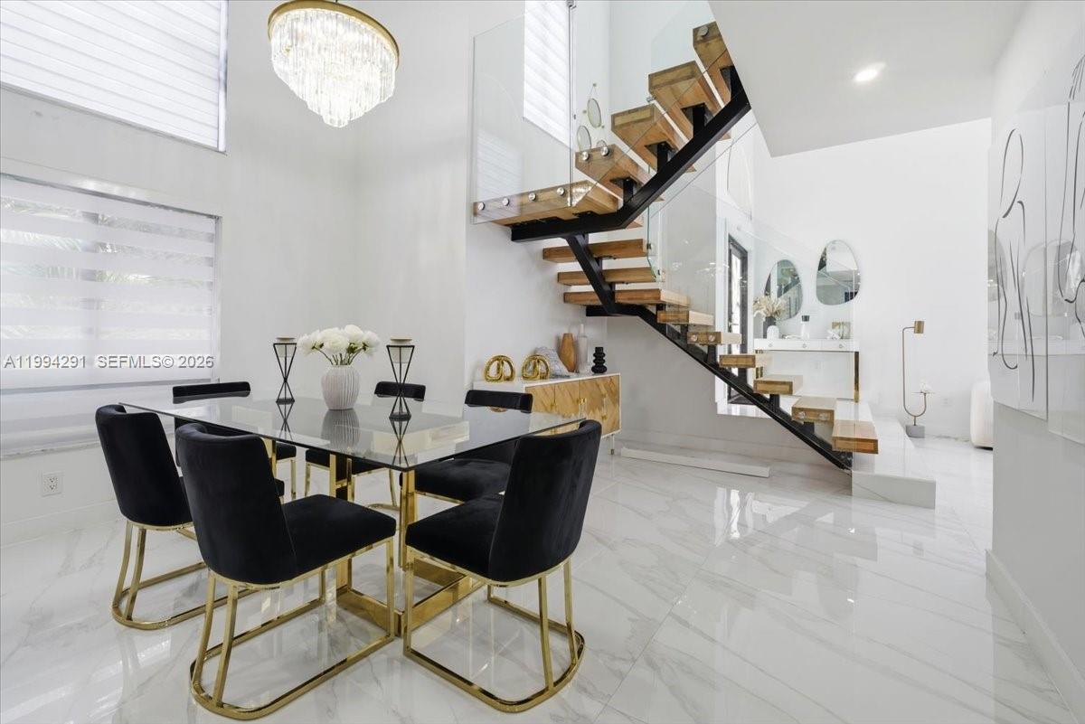 15763 Southwest 43rd Street Miami, FL 33185 - Photo 18 of 46 a dining room with wooden floor and a chandelier