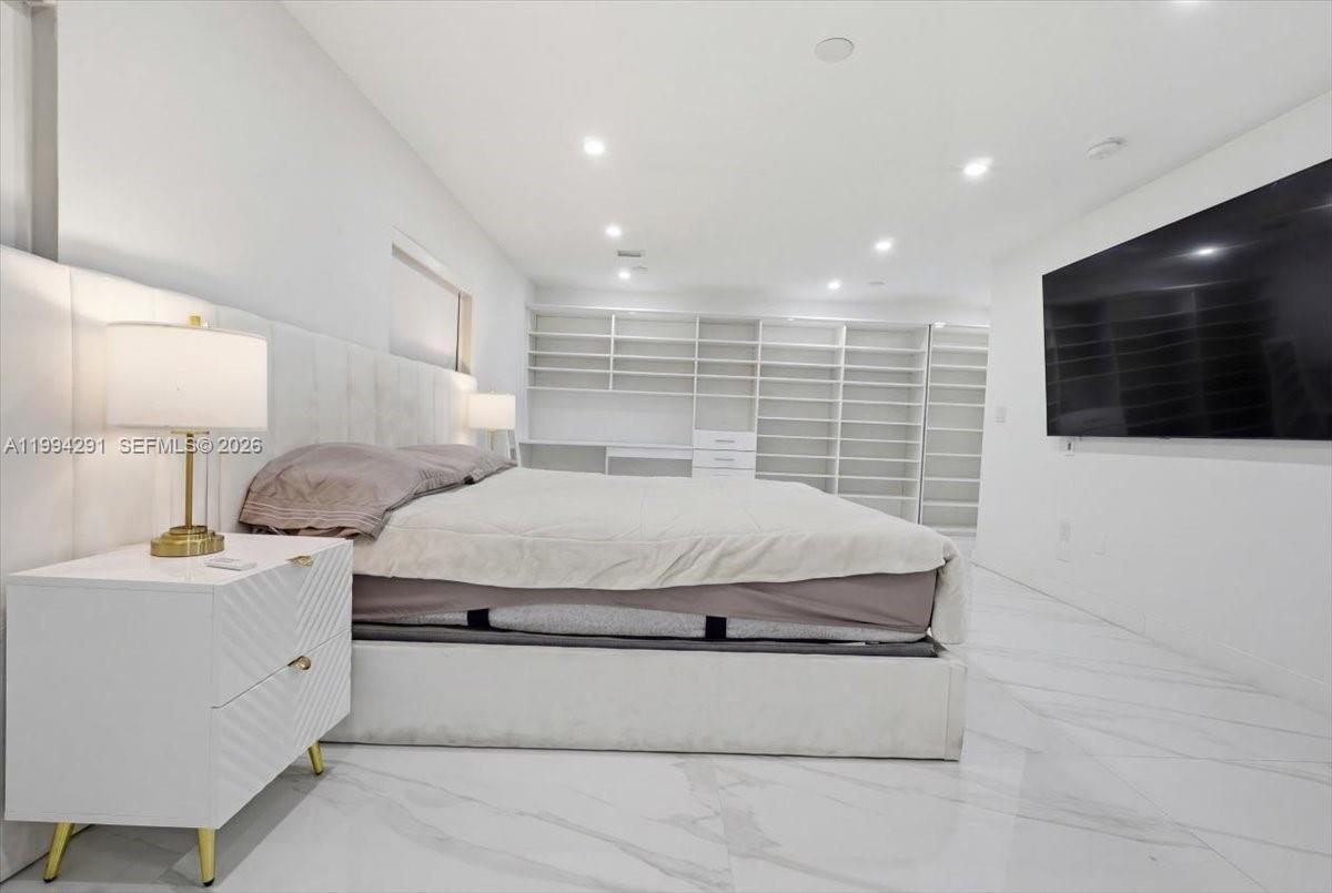 15763 Southwest 43rd Street Miami, FL 33185 - Photo 25 of 46 a spacious bedroom with a bed and a flat screen tv