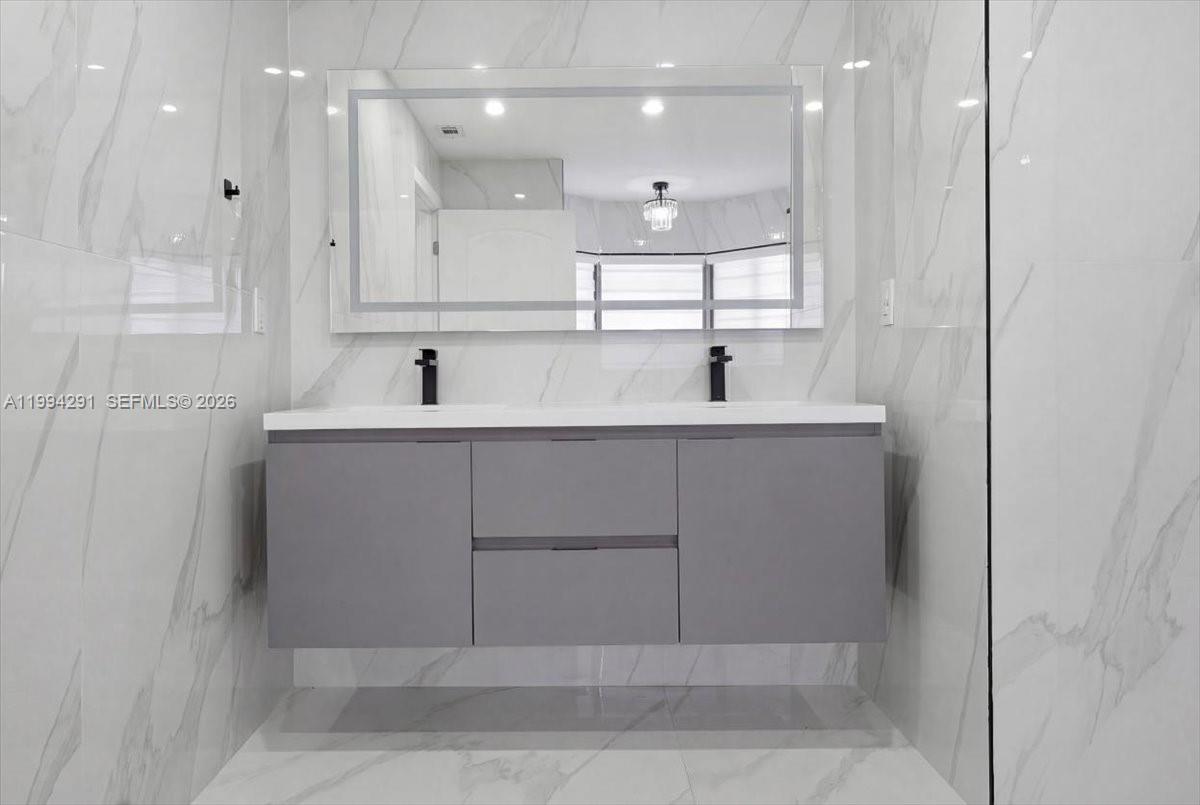 15763 Southwest 43rd Street Miami, FL 33185 - Photo 27 of 46 a bathroom with a sink a large mirror and shower