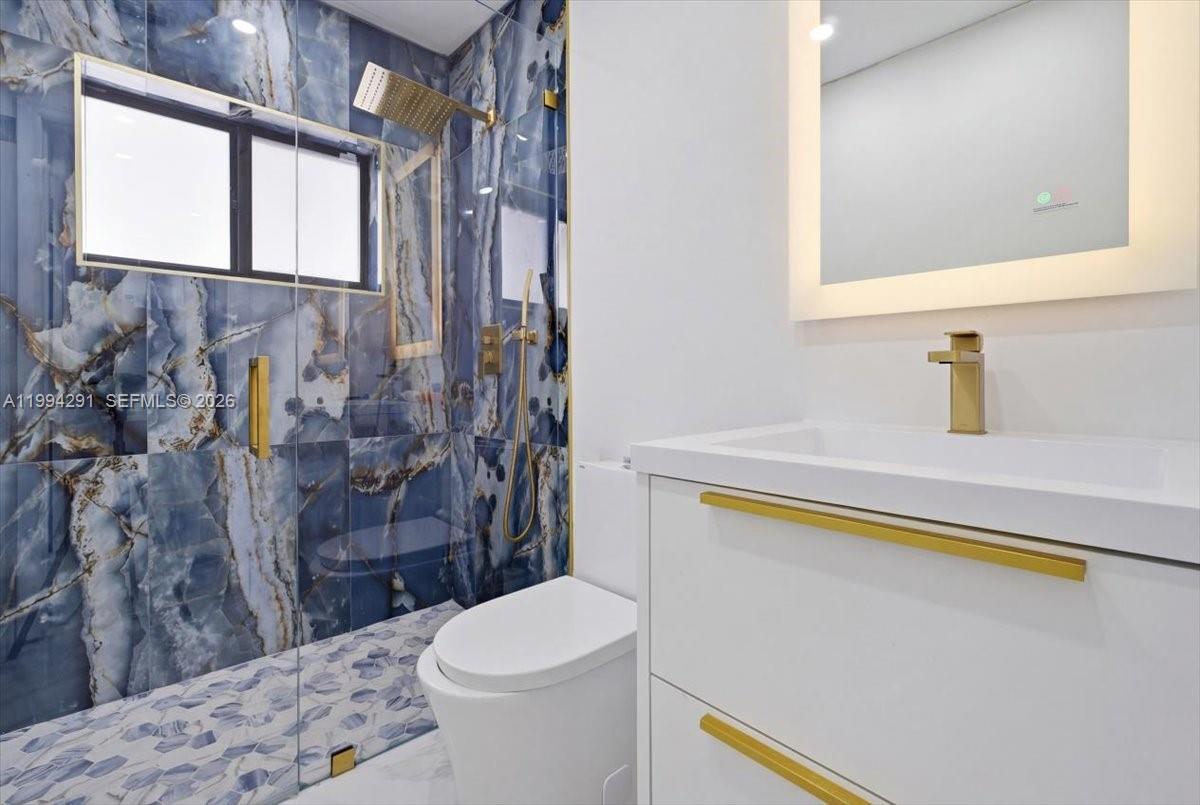 15763 Southwest 43rd Street Miami, FL 33185 - Photo 32 of 46 a bathroom with a sink a toilet and shower