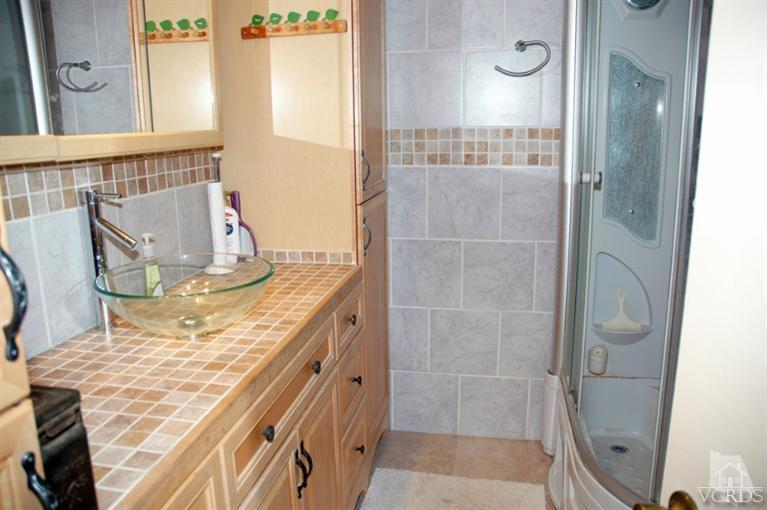 1764 Fitzgerald Road Simi Valley, CA 93065 - Photo 14 of 16 a bathroom with a granite countertop shower a mirror and a sink