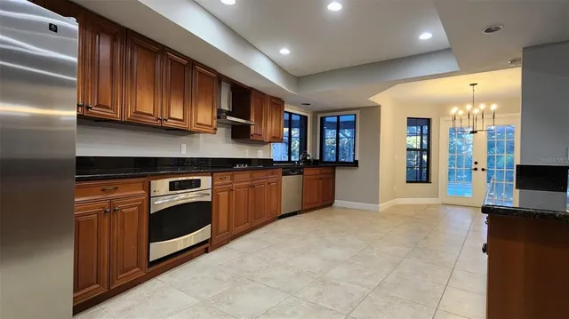 a kitchen with stainless steel appliances granite countertop a refrigerator and a sink
