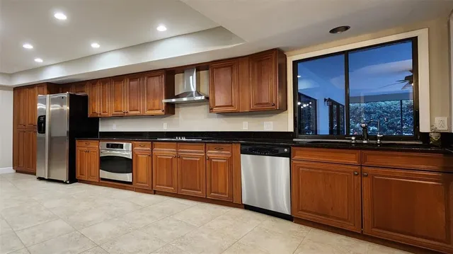 a view of a kitchen with refrigerator and windows