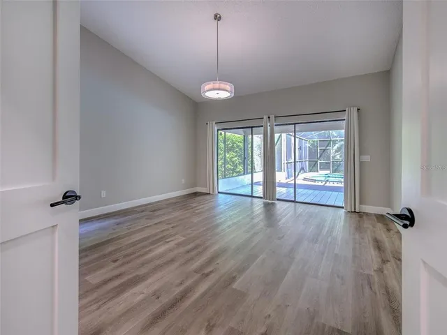 a view of empty room with wooden floor