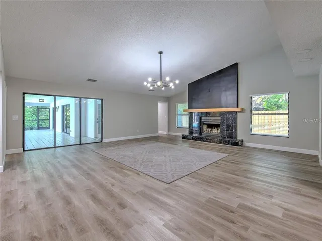 an empty room with fireplace cabinet and windows