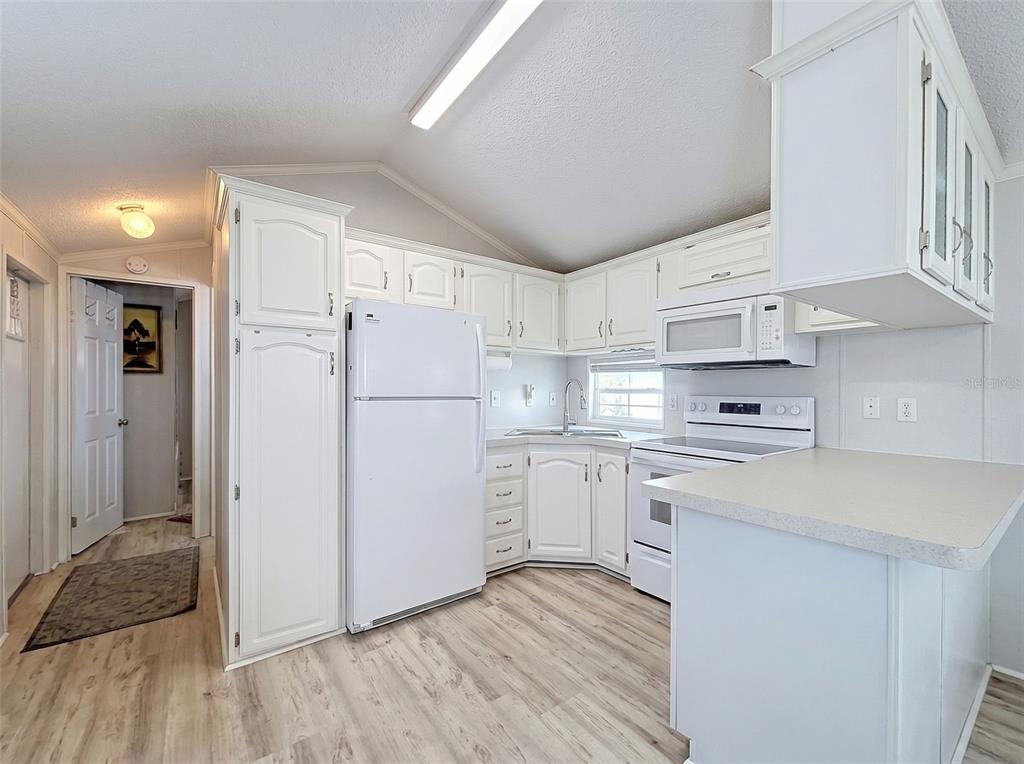2092 Culbreath Road, Unit A42 Brooksville, FL 34602 - Photo 68 of 70 a kitchen with white cabinets and white appliances