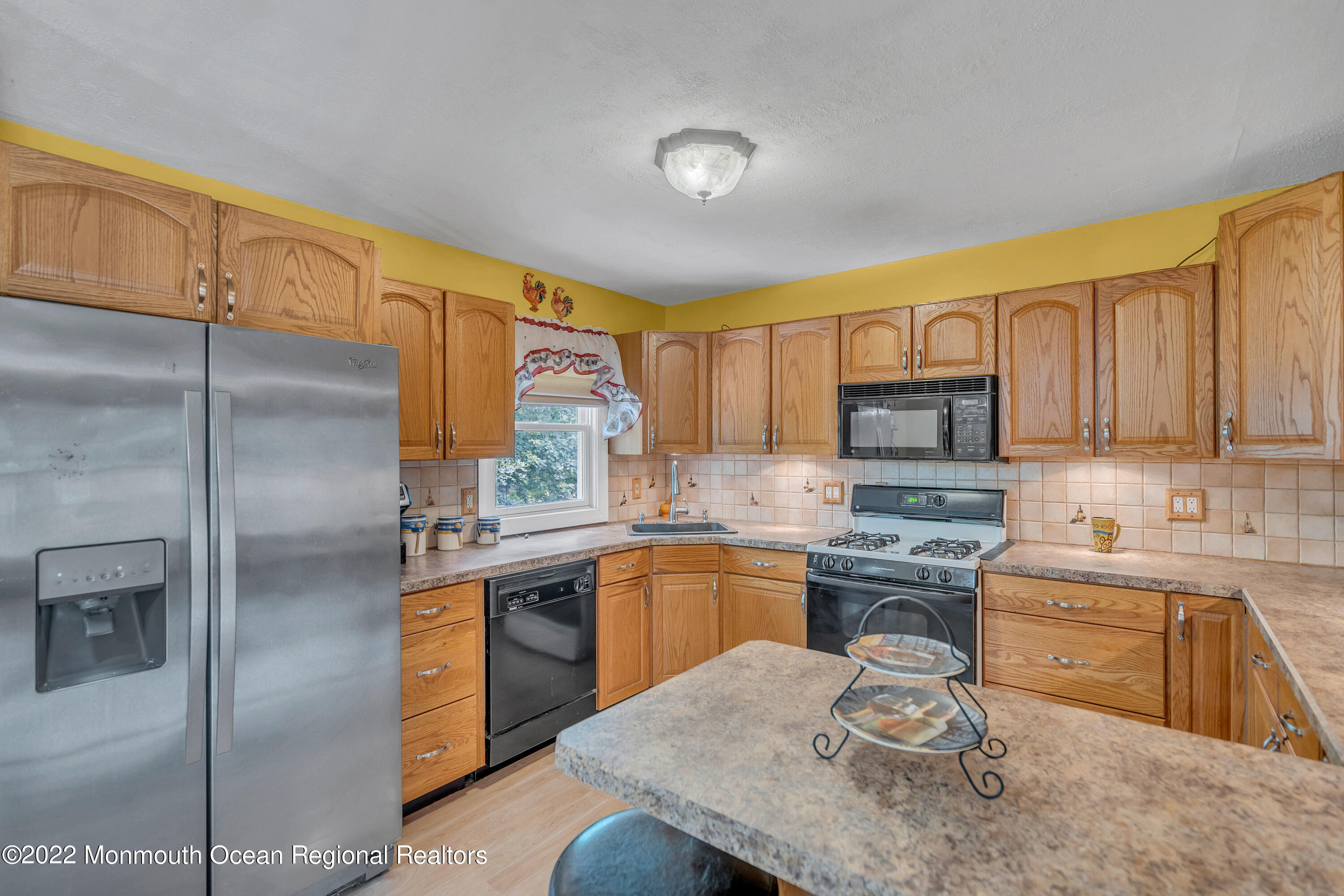 148 Weldon Road Manchester Township, NJ 08759 - Photo 18 of 36 a kitchen with stainless steel appliances granite countertop a sink a stove a refrigerator cabinets and a dining table