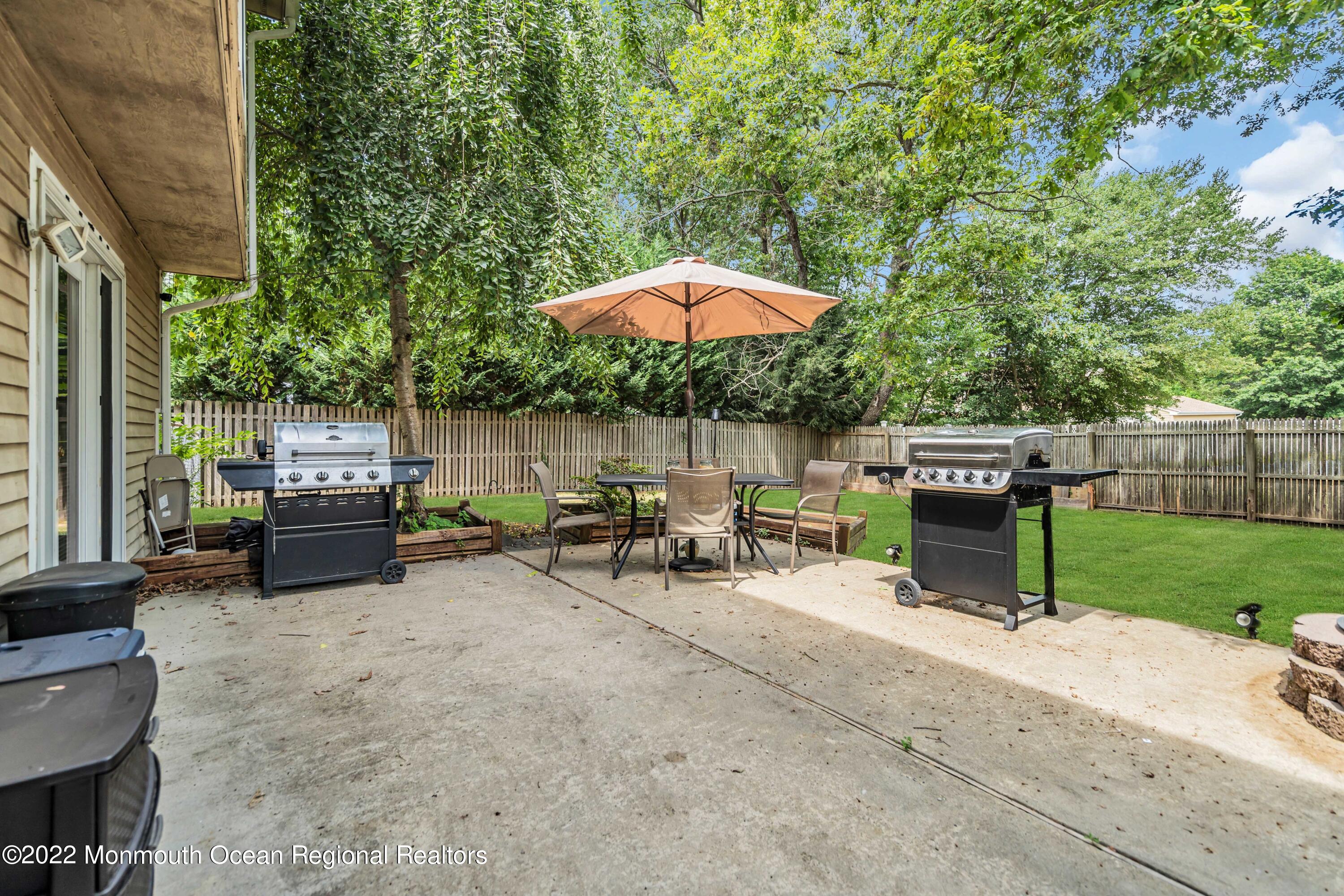 148 Weldon Road Manchester Township, NJ 08759 - Photo 31 of 36 a view of backyard with a table and chairs under an umbrella