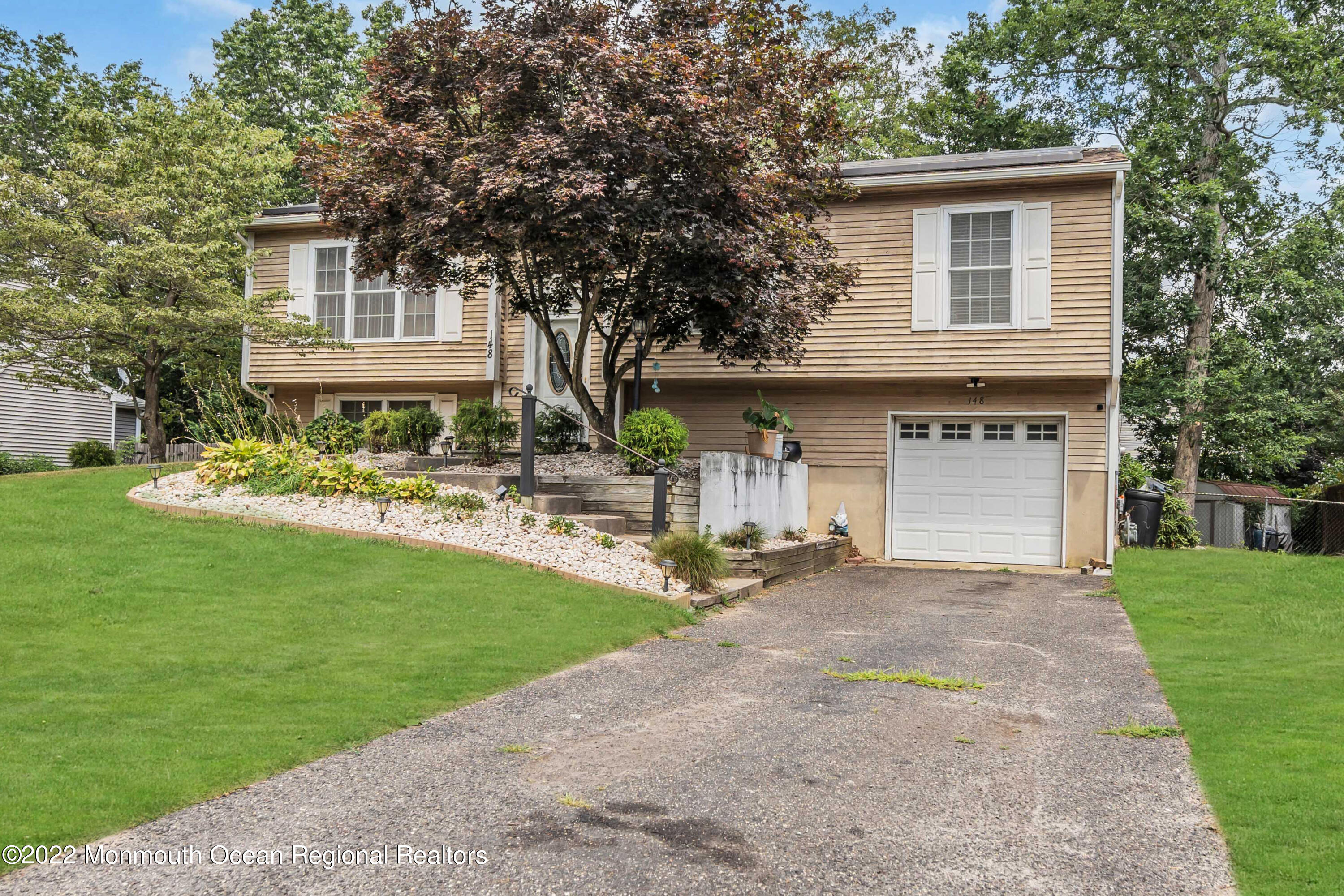 148 Weldon Road Manchester Township, NJ 08759 - Photo 6 of 36 a front view of a house with a garden and trees