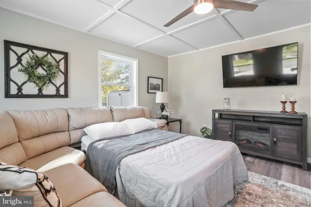 a bedroom with a large bed couch and window