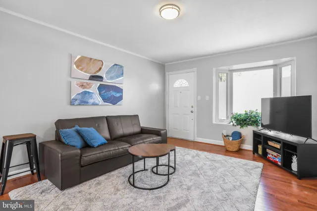 a living room with furniture a flat screen tv and a window